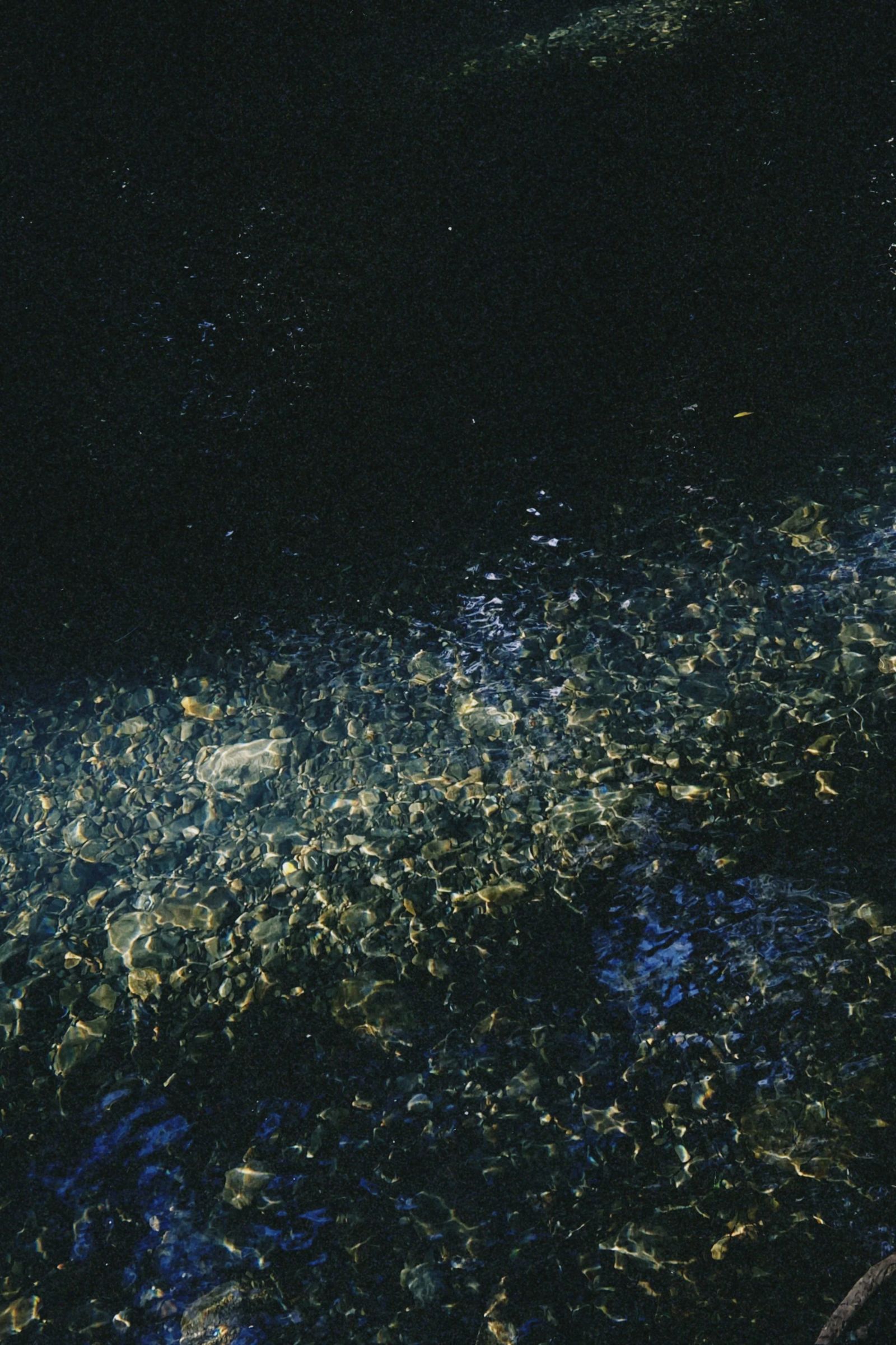 Stones under clear dark water in Never Never Creek