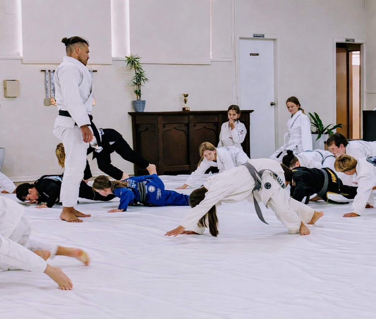 An instructor watches students drill on the mats at Point Break in Bellingen